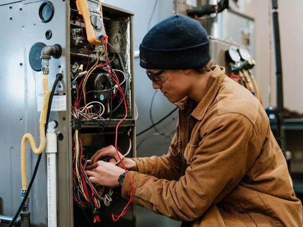 male student working on a HVAC wiring system